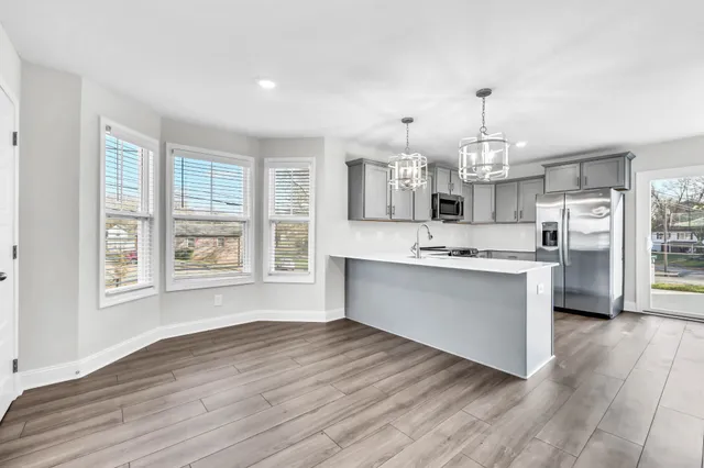 a large kitchen with cabinets wooden floor and stainless steel appliances
