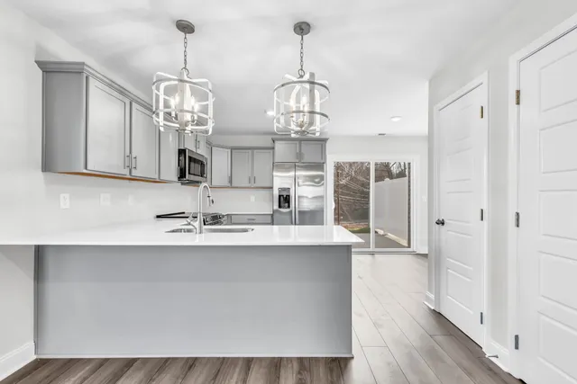 a view of a kitchen with stainless steel appliances granite countertop a sink and wooden floor