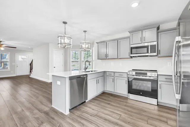 a kitchen with stainless steel appliances granite countertop a stove a sink and a refrigerator