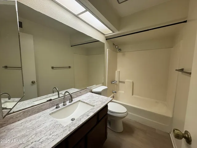 a bathroom with a granite countertop sink toilet and shower