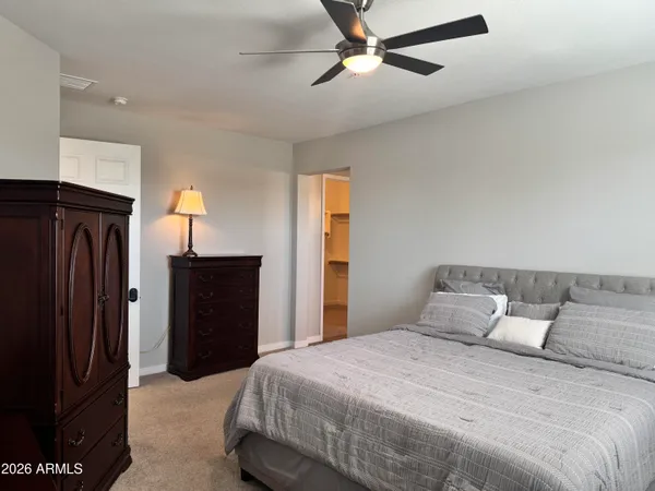 a bedroom with a bed and a refrigerator