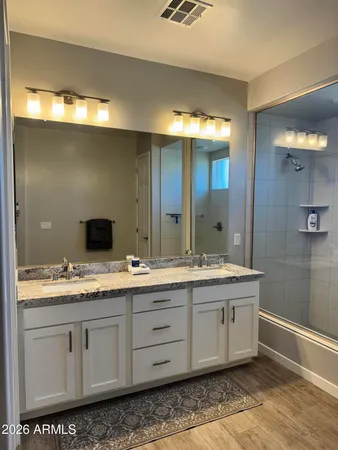 a bathroom with a double vanity sink and mirror