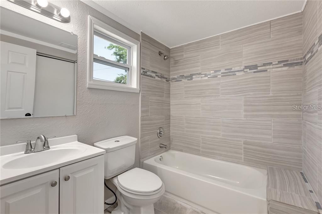 2523 West Spruce Street Tampa, FL 33607 - Photo 11 of 15 a bathroom with a granite countertop toilet a sink and bathtub