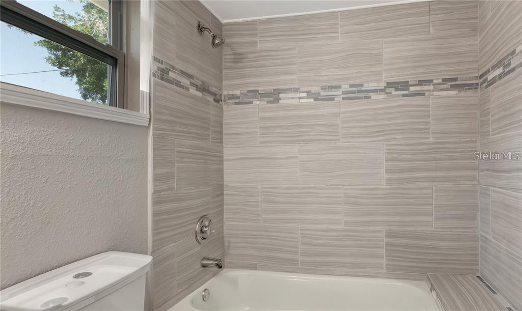 2523 West Spruce Street Tampa, FL 33607 - Photo 12 of 15 a bathroom with a shower and a toilet
