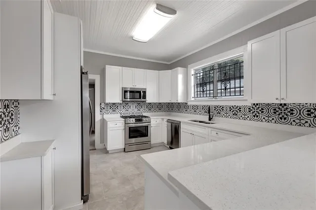a kitchen with granite countertop white cabinets and white stainless steel appliances