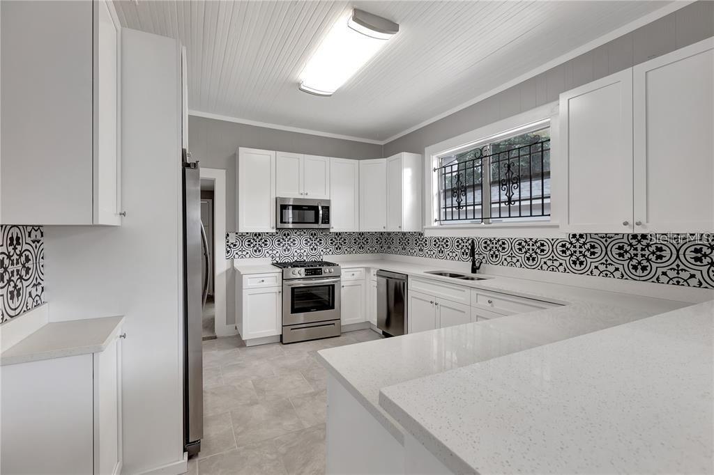 2523 West Spruce Street Tampa, FL 33607 - Photo 2 of 15 a kitchen with granite countertop white cabinets and white stainless steel appliances