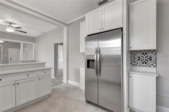 a kitchen with white cabinets and stainless steel appliances