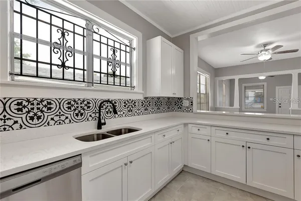a kitchen with white cabinets and sink
