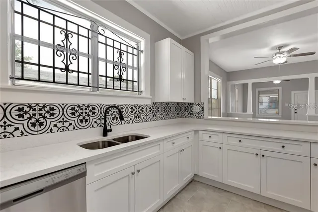 a kitchen with white cabinets and sink