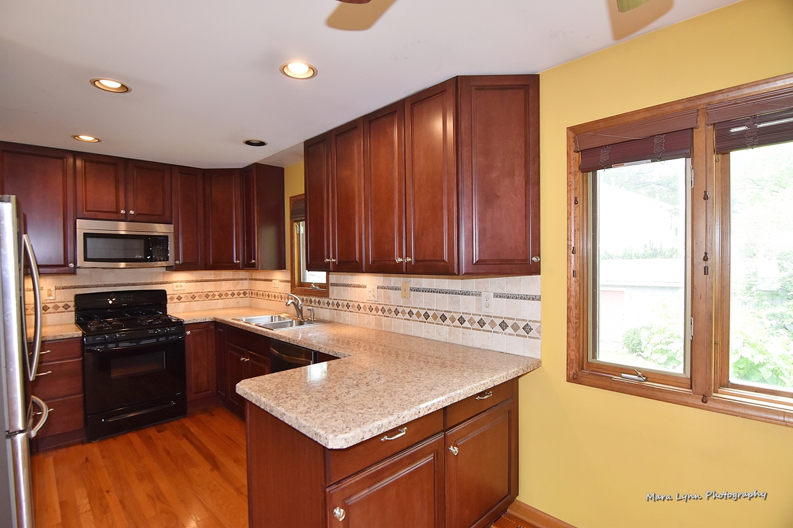 1424 Sunset Road Geneva, IL 60134 - Photo 6 of 38 a kitchen with kitchen island granite countertop a sink stove and refrigerator