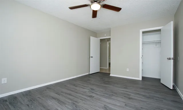 a view of an empty room with wooden floor