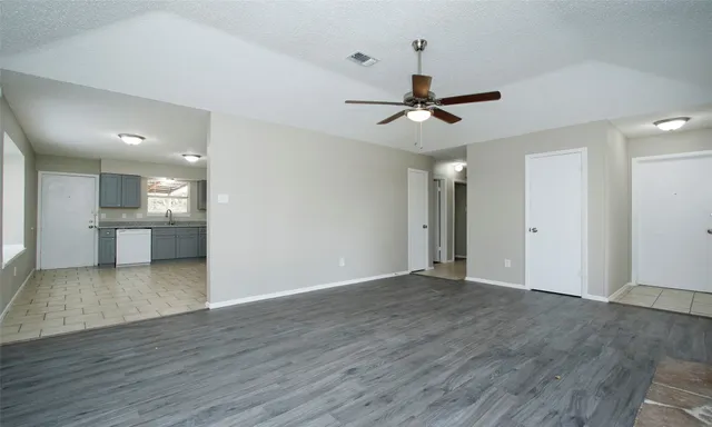 a view of a kitchen with wooden floor and a ceiling fan