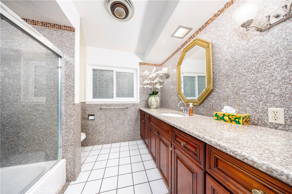 648 Sharon Road Arcadia, CA 91007 - Photo 13 of 26 a bathroom with a granite countertop sink a mirror and a bathtub