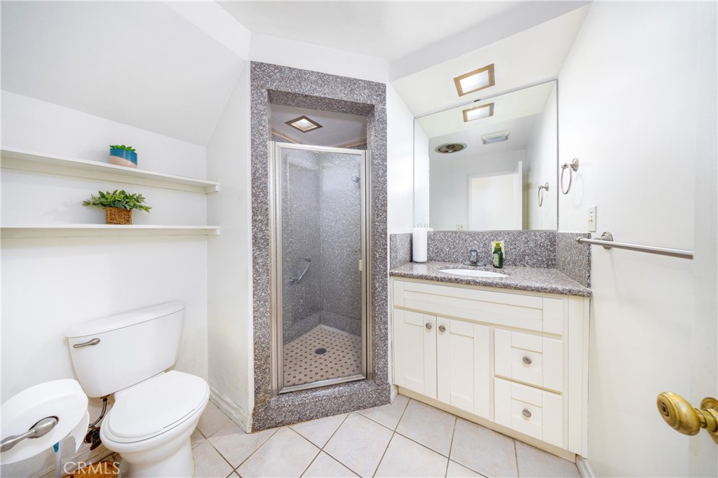 648 Sharon Road Arcadia, CA 91007 - Photo 14 of 26 a bathroom with a granite countertop toilet a sink and a mirror