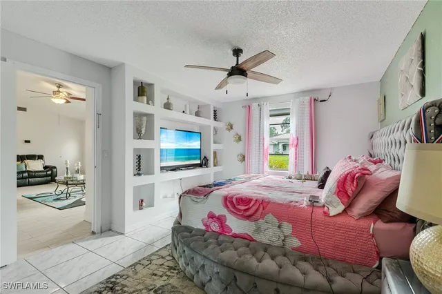 a bedroom with a bed a chandelier and dresser