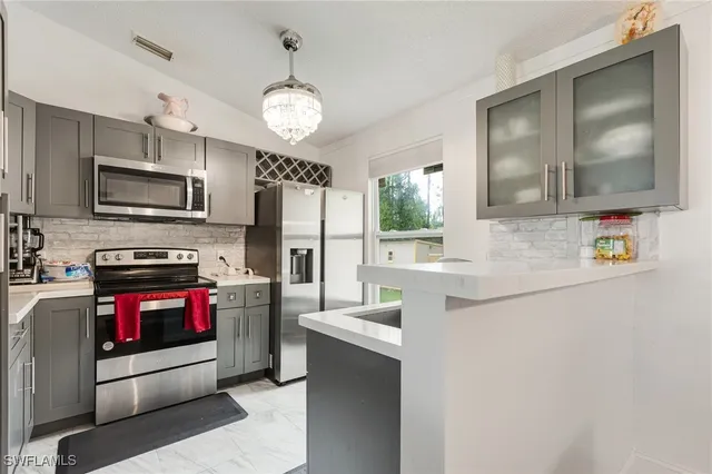 a kitchen with stainless steel appliances a stove microwave and refrigerator