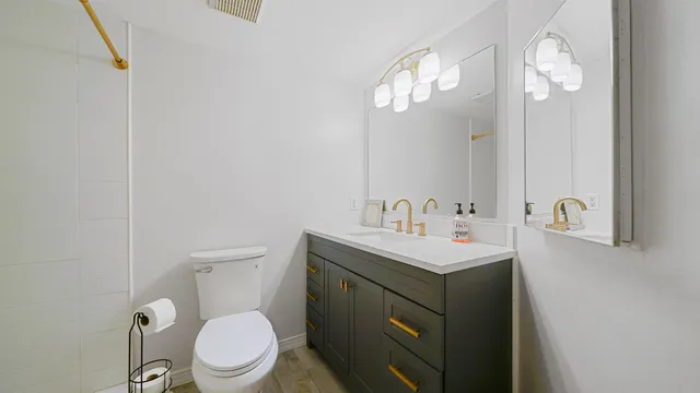 a bathroom with a toilet sink and mirror