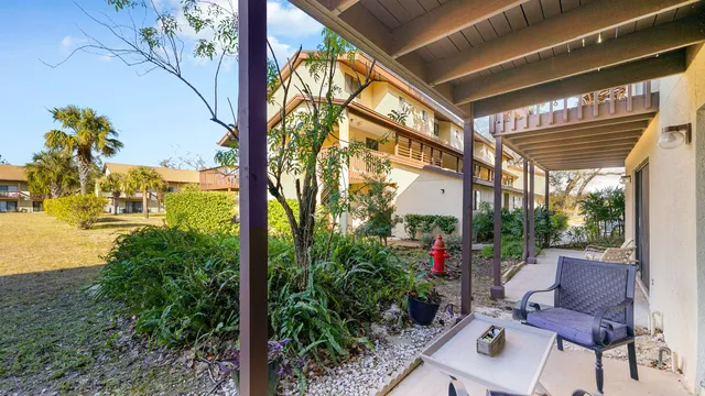 a porch with a table and chairs and potted plants