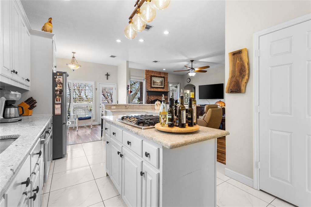 1007 Santa Fe Street Denton, TX 76205 - Photo 37 of 37 Kitchen featuring white cabinets, open floor plan, light stone countertops, stainless steel appliances, and ceiling fan