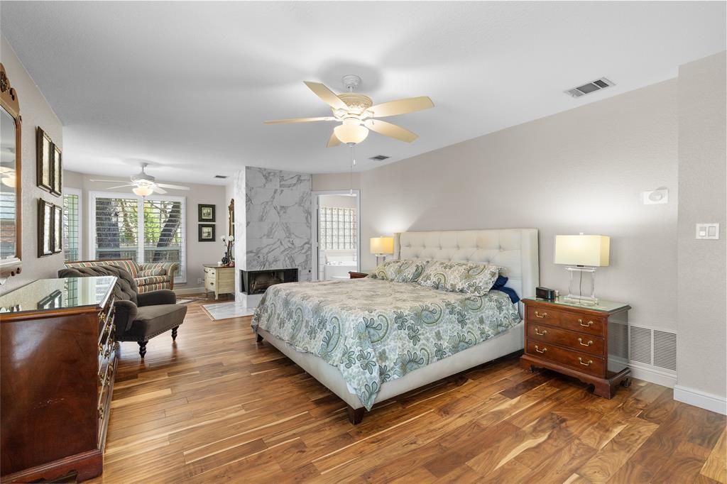 1007 Santa Fe Street Denton, TX 76205 - Photo 15 of 37 Bedroom with dark wood finished floors, ceiling fan, and a high end fireplace