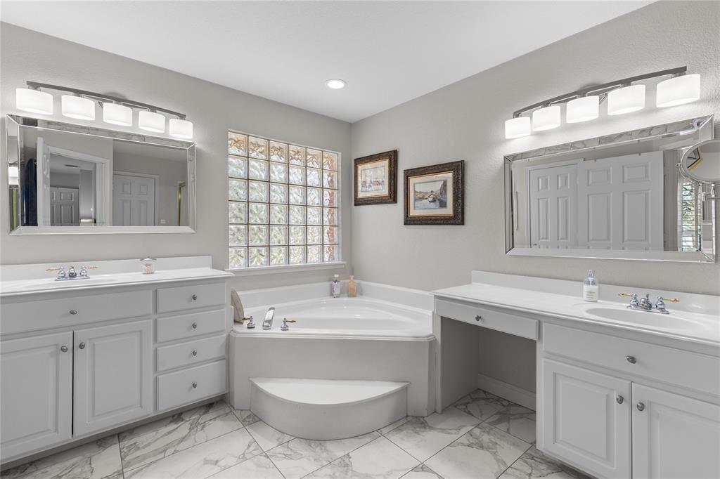 1007 Santa Fe Street Denton, TX 76205 - Photo 17 of 37 Full bath featuring two vanities, a garden tub, and light marble finish flooring