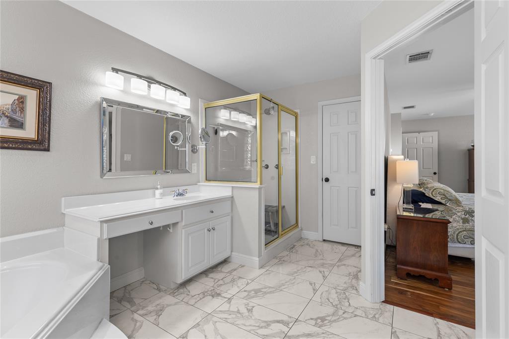 1007 Santa Fe Street Denton, TX 76205 - Photo 18 of 37 Ensuite bathroom with vanity, a shower stall, light marble finish flooring, and a garden tub