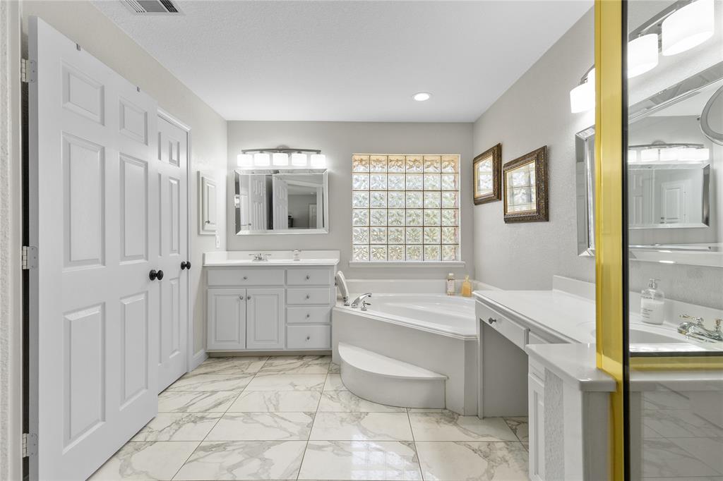 1007 Santa Fe Street Denton, TX 76205 - Photo 19 of 37 Bathroom featuring a garden tub, light marble finish floors, and two vanities