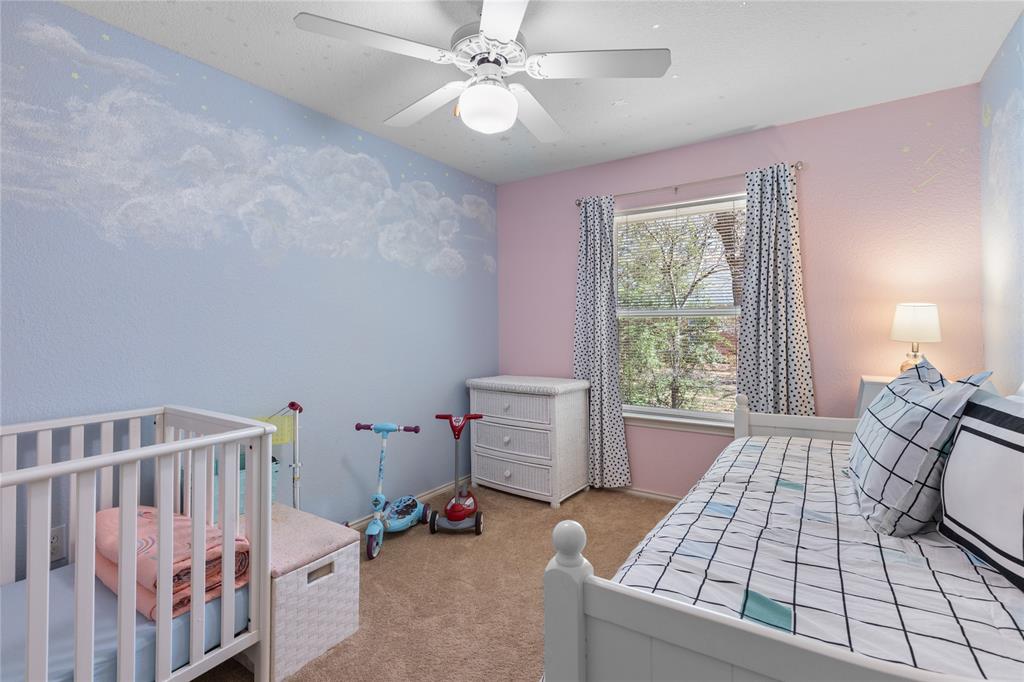 1007 Santa Fe Street Denton, TX 76205 - Photo 22 of 37 Bedroom featuring light carpet, a crib, and a ceiling fan