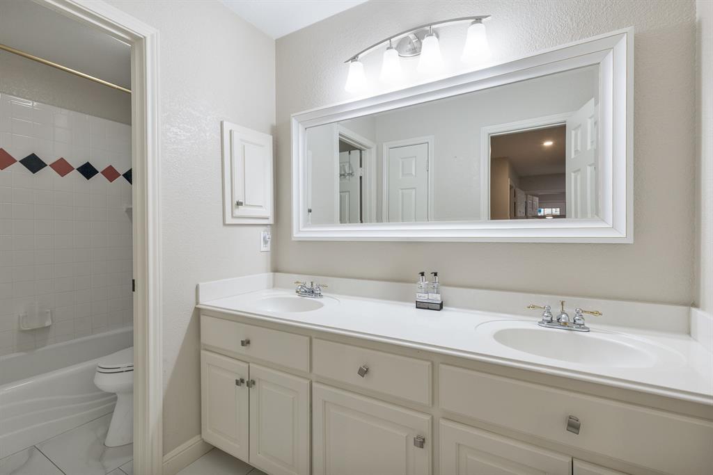 1007 Santa Fe Street Denton, TX 76205 - Photo 24 of 37 Bathroom with double vanity, shower / tub combination, and a textured wall