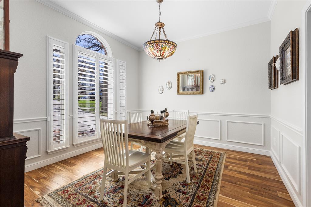 1007 Santa Fe Street Denton, TX 76205 - Photo 6 of 37 Dining space with a decorative wall, healthy amount of natural light, a wainscoted wall, crown molding, and wood finished floors