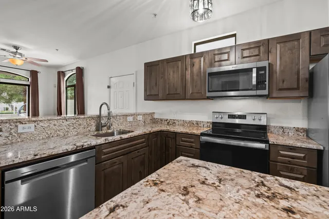 a kitchen with stainless steel appliances kitchen island granite countertop a stove sink and microwave