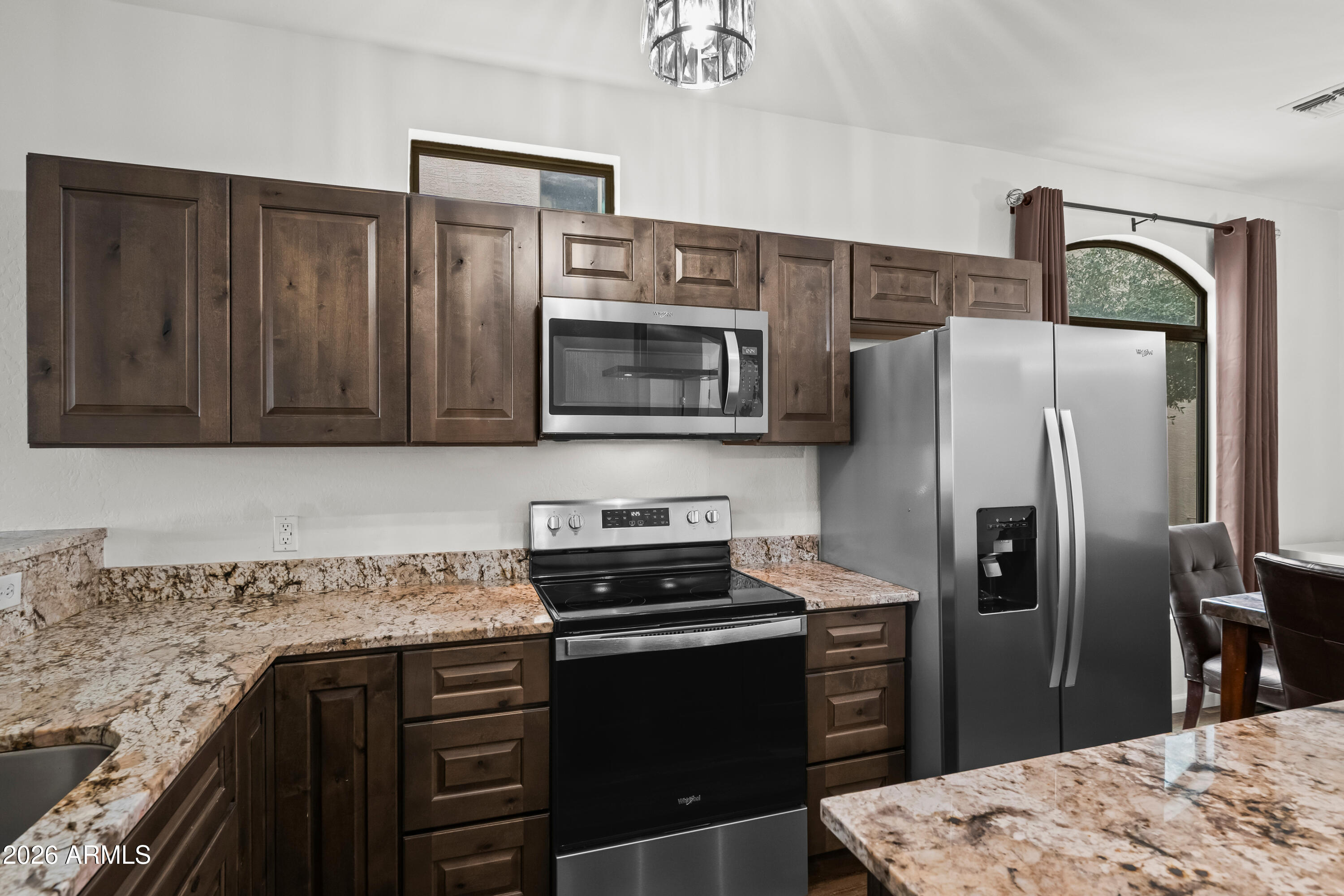 2150 East Bell Road, Unit 1159 Phoenix, AZ 85022 - Photo 2 of 26 a kitchen with granite countertop a refrigerator stove and microwave