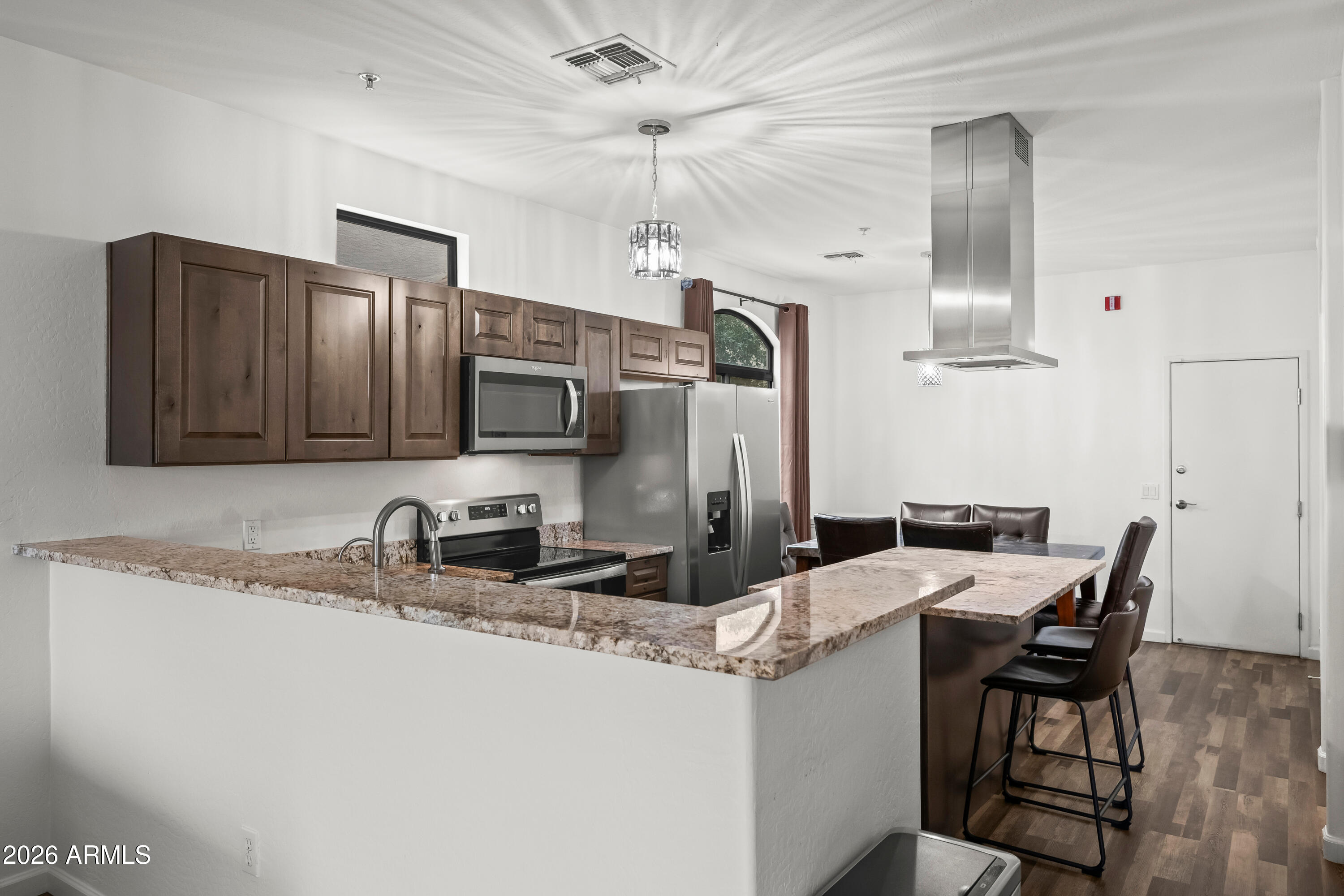 2150 East Bell Road, Unit 1159 Phoenix, AZ 85022 - Photo 3 of 26 a kitchen with stainless steel appliances granite countertop a sink a stove a refrigerator cabinets and chairs