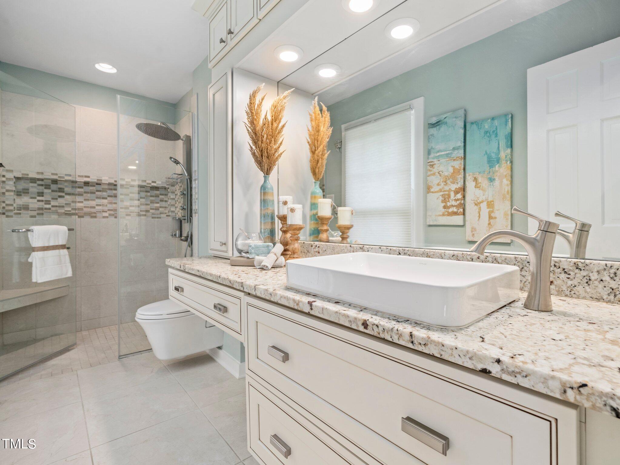 7800 Whitley Drive Raleigh, NC 27613 - Photo 9 of 17 a bathroom with a granite countertop sink a toilet and a large mirror