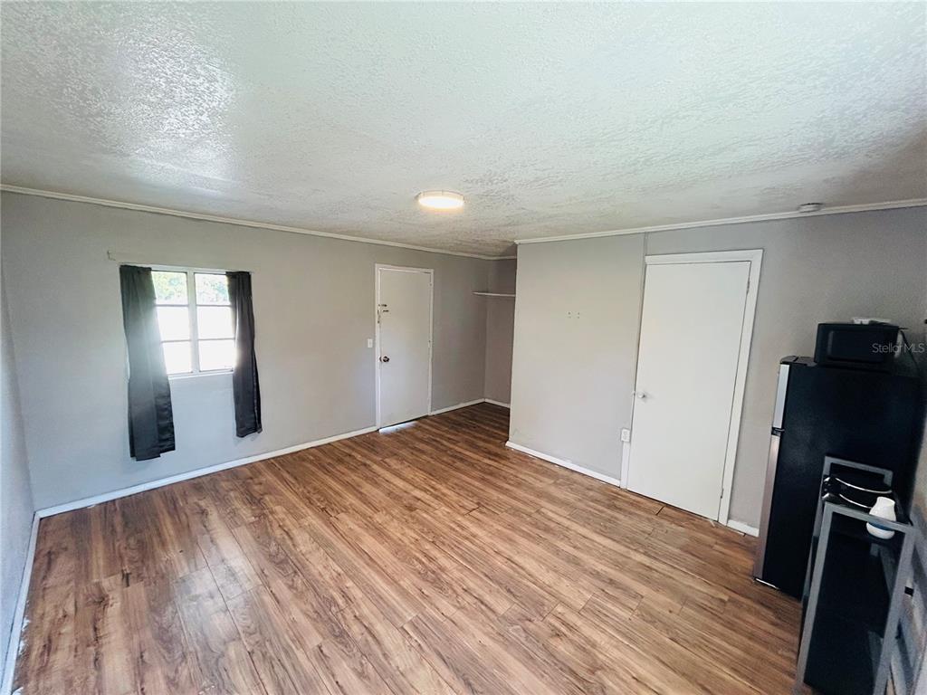 553597 Highway 1, Unit 2 Hilliard, FL 32046 - Photo 3 of 5 a view of empty room with wooden floor and fan
