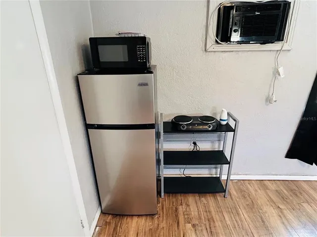 a walk in closet with wooden floor