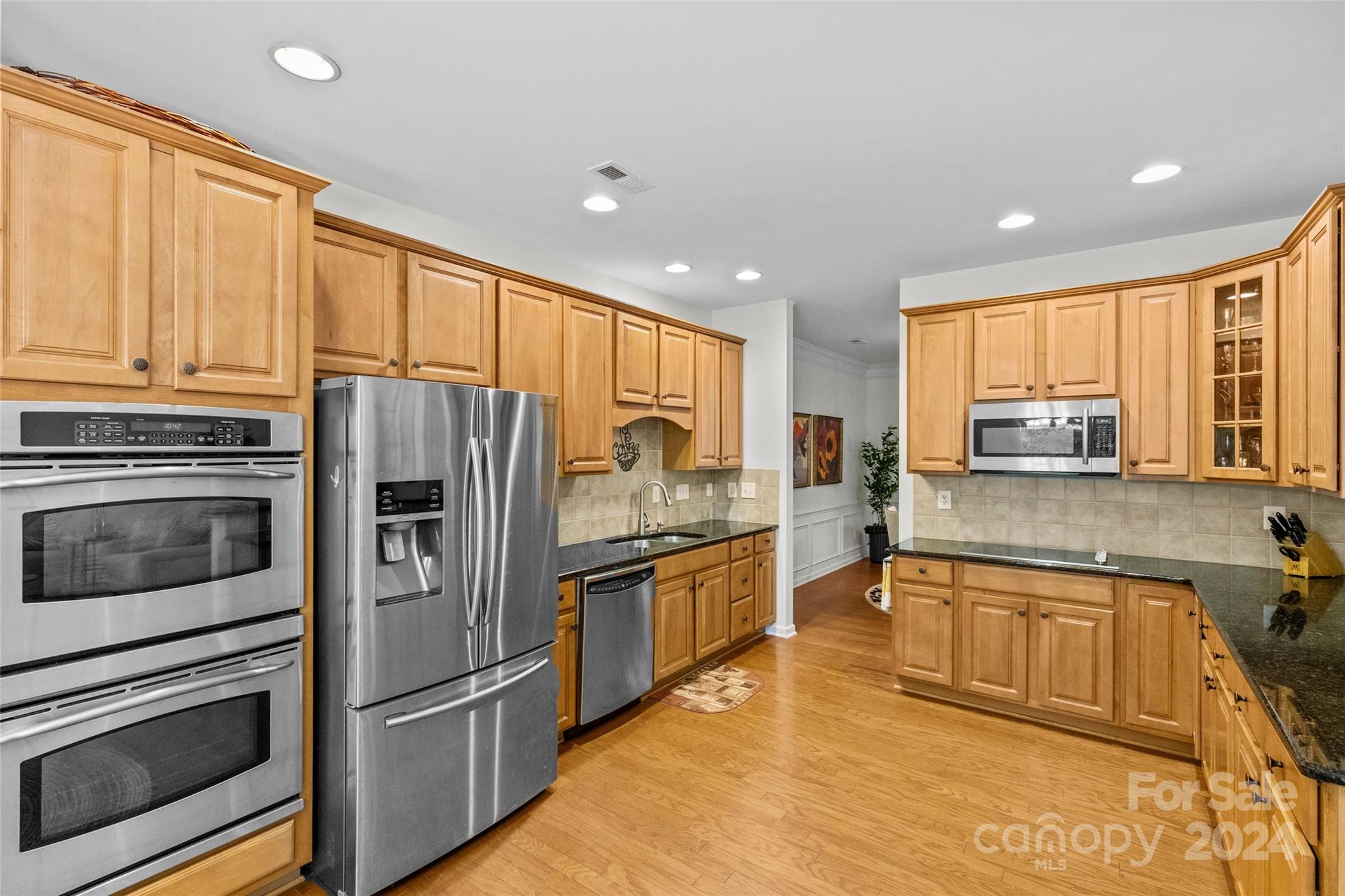 1034 Silver Gull Drive Tega Cay, SC 29708 - Photo 8 of 32 a kitchen with stainless steel appliances granite countertop a refrigerator a sink dishwasher a stove and white countertops with wooden floor