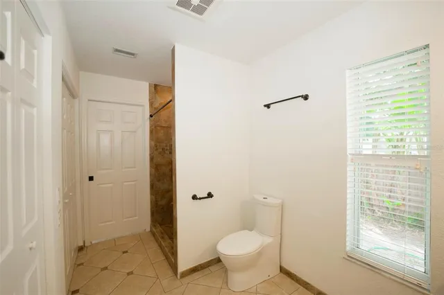 a bathroom with a granite countertop sink a toilet and shower
