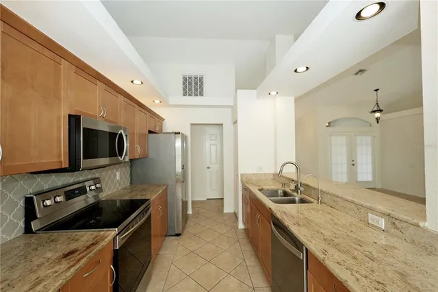 a kitchen with stainless steel appliances granite countertop a sink stove and refrigerator