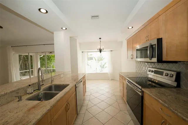 a kitchen that has a sink cabinets counter space and stainless steel appliances
