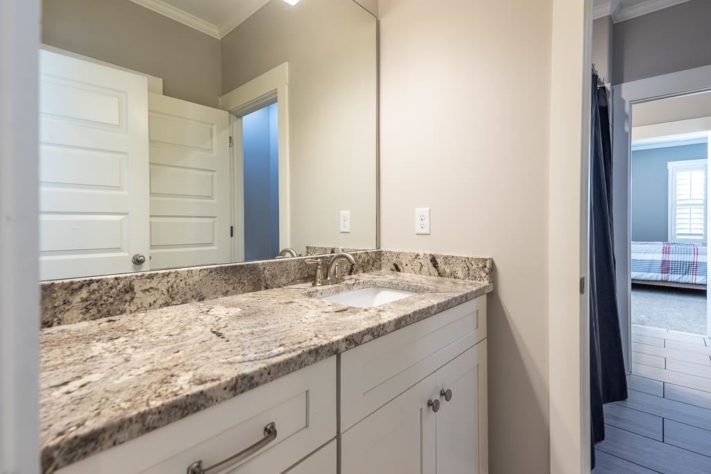 328 Washington Street Collierville, TN 38017 - Photo 26 of 33 Bathroom vanity featuring a light-toned stone countertop with an undermount sink and brushed nickel faucet