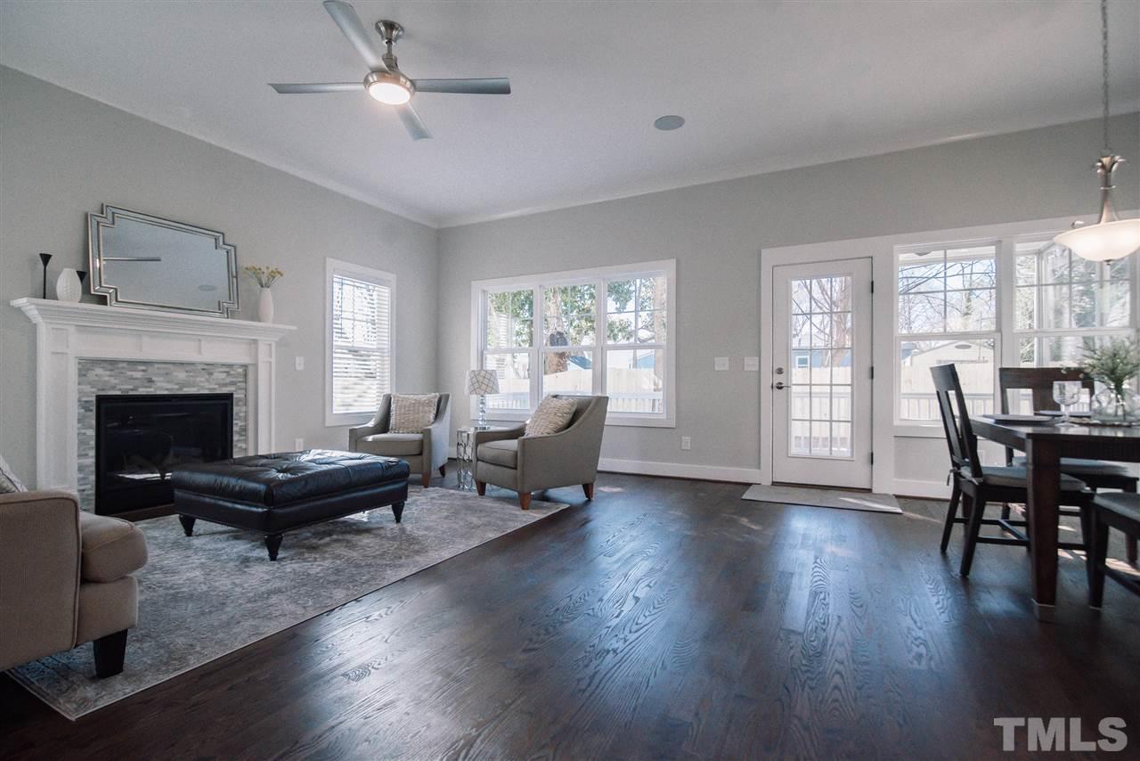 1508 East Lane Street Raleigh, NC 27610 - Photo 18 of 30 a living room with couches a fireplace and a dining table with wooden floor