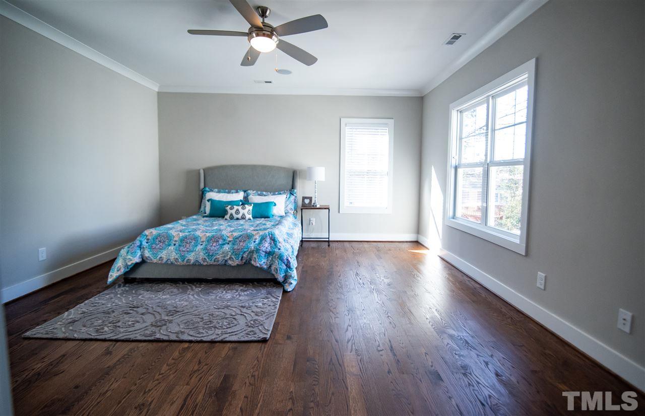 1508 East Lane Street Raleigh, NC 27610 - Photo 21 of 30 a bedroom with a large bed and wooden floor