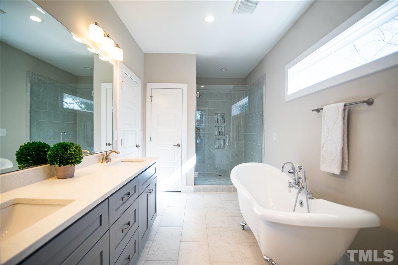 1508 East Lane Street Raleigh, NC 27610 - Photo 23 of 30 a bathroom with a double vanity sink a mirror and a bathtub