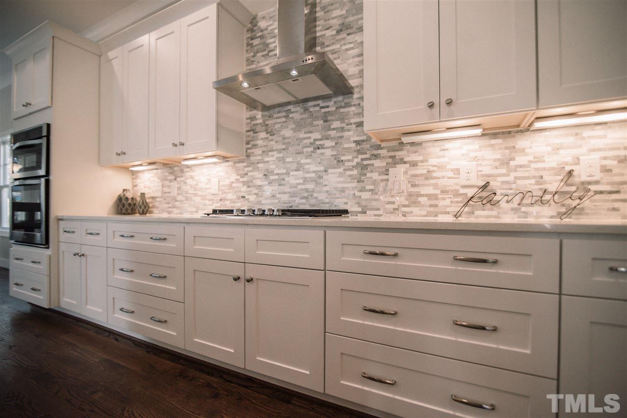 1508 East Lane Street Raleigh, NC 27610 - Photo 9 of 30 a kitchen with granite countertop white cabinets and white appliances