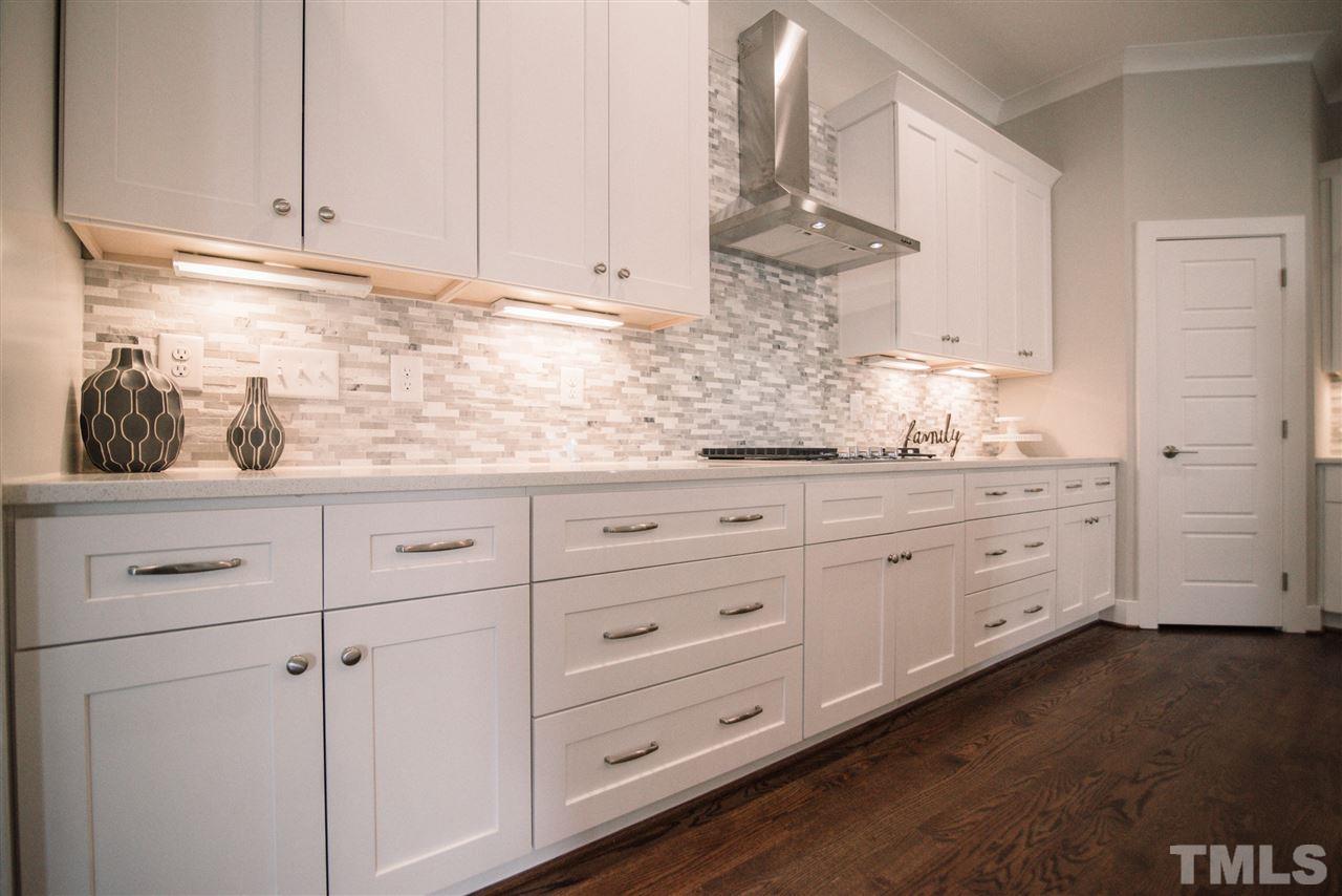 1508 East Lane Street Raleigh, NC 27610 - Photo 10 of 30 a kitchen with white cabinets and white appliances