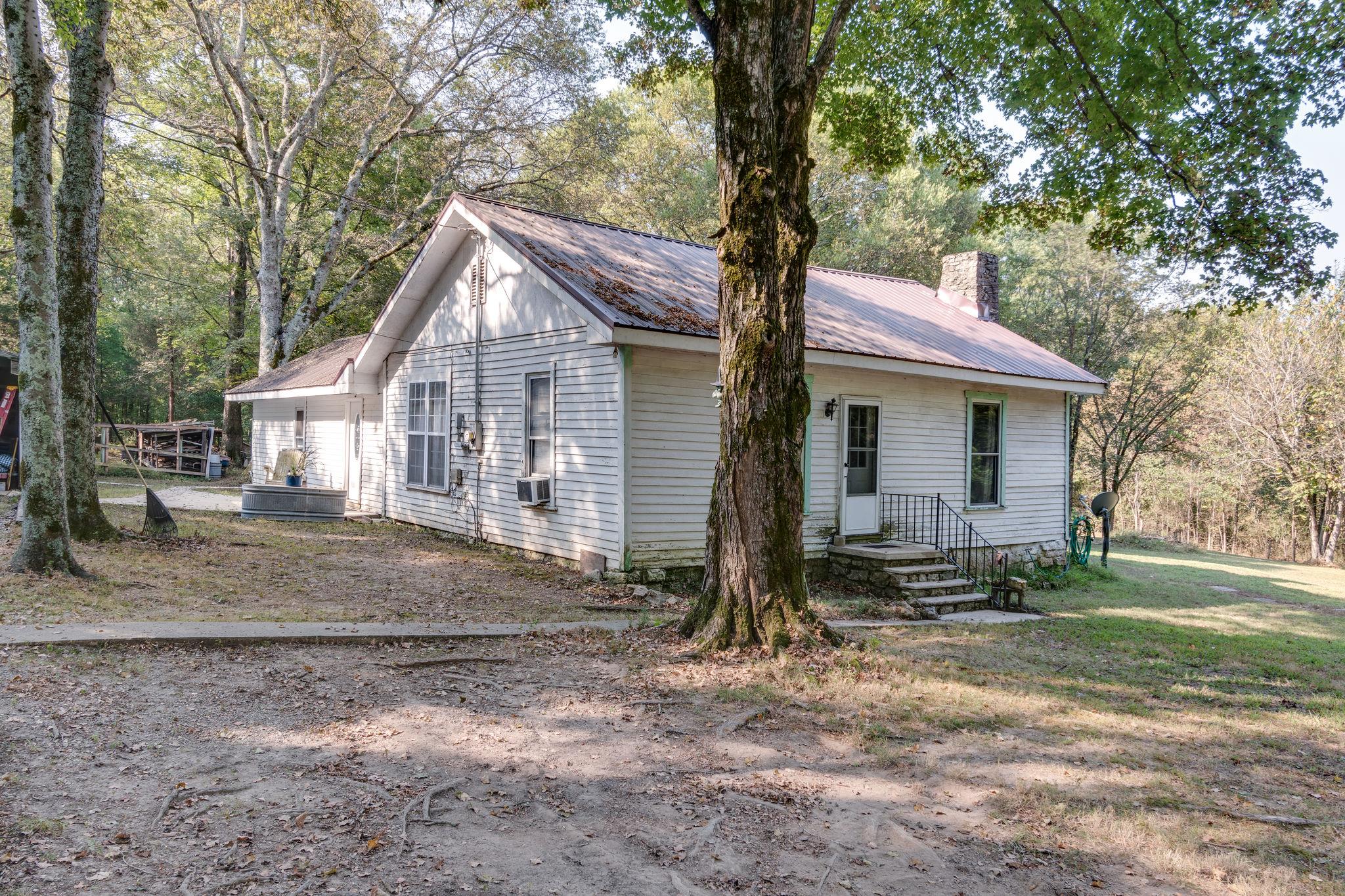 1452 Iron Bridge Road Columbia, TN 38401 - Photo 3 of 19 a small white house with a white roof and wooden fence