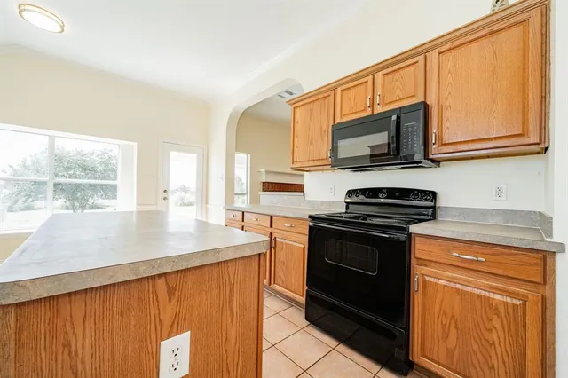 a kitchen with stainless steel appliances granite countertop a stove top oven a sink a counter top space and cabinets