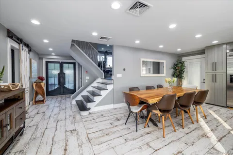 a living room with furniture a floor to ceiling window and kitchen view