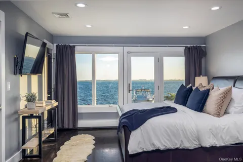 a spacious bedroom with a bed and wooden floor